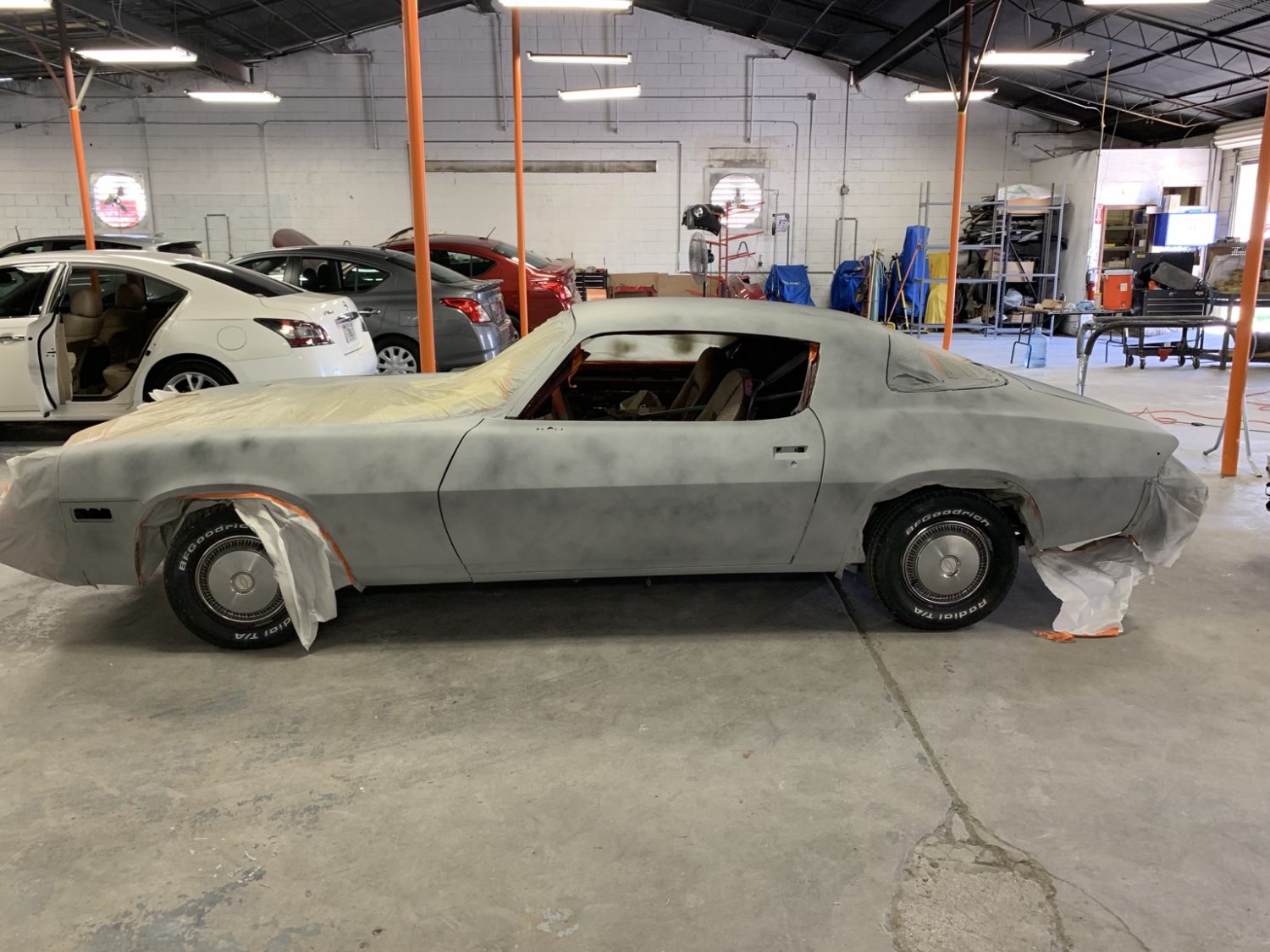 Classic car in primer being prepped for paint at McCoy Enterprises