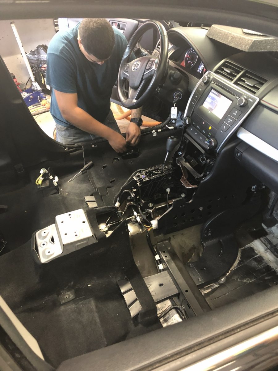 McCoy Enterprises technician performing detailed interior electrical work in the Orlando shop